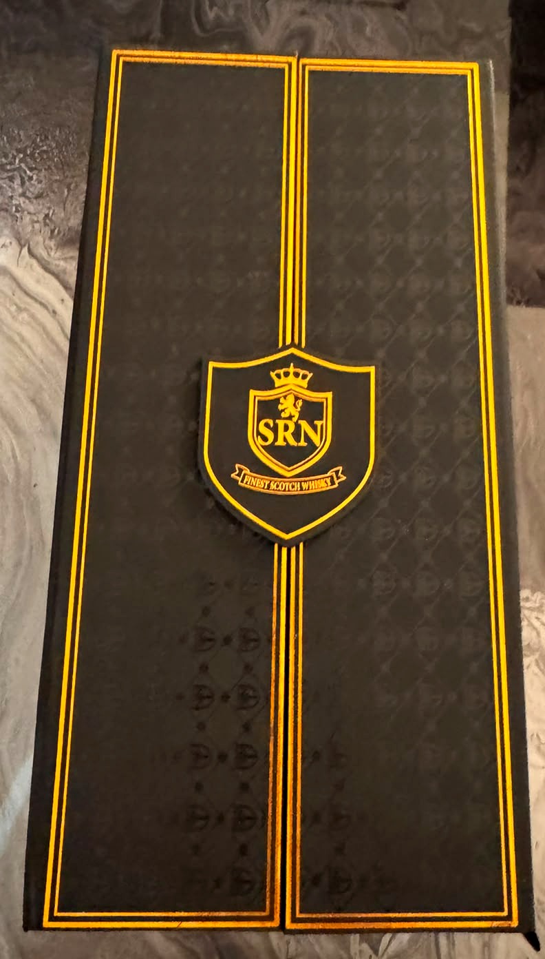Close-up of the closed Noctara presentation box lid with copper border lines and the raised SRN crest reading Finest Scotch Whisky
